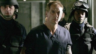 Vladimir Bierko (Julian Sands) is escorted by armed guards in 24 Season 5 Episode 21