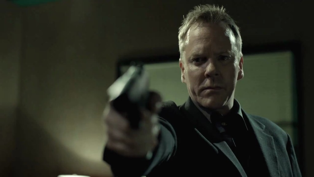 Kiefer Sutherland in The Confession pointing gun