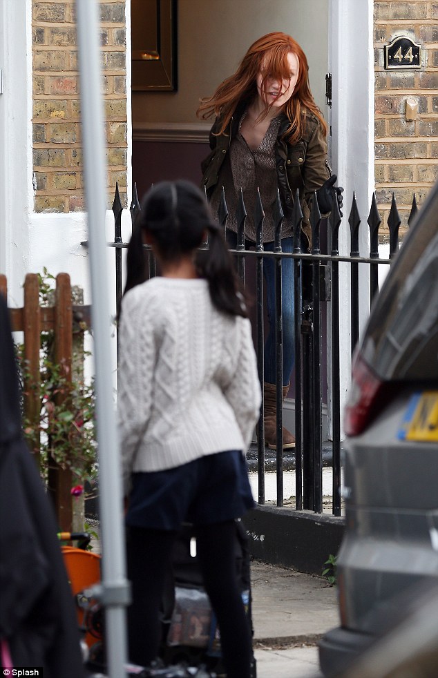 She is chasing a young girl out of a terraced house